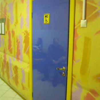 Синяя пластиковая дверь в больнице с желтым наличником